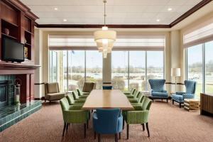 une salle de conférence avec une table, des chaises et une cheminée dans l'établissement Hilton Garden Inn Dubuque Downtown, à Dubuque