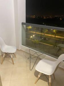 a room with two chairs and a large window at Appartement Anir in Agadir