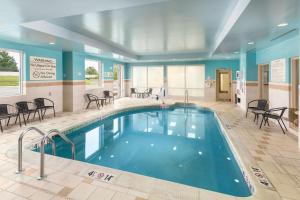 a pool in a hotel room with tables and chairs at Hilton Garden Inn Silver Spring White Oak in Silver Spring