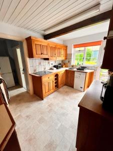 a large kitchen with wooden cabinets at The Snuggery Cottage in Taunton