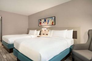 a hotel room with two beds and a chair at Hilton Garden Inn Tysons Corner in Tysons Corner