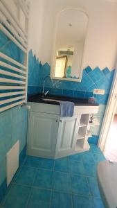 uma casa de banho azul com um lavatório e um espelho em Dimora Sorrento em Sant'Agnello