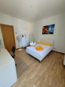 ein Schlafzimmer mit einem großen weißen Bett und einem Ventilator in der Unterkunft Kalimera in Bari