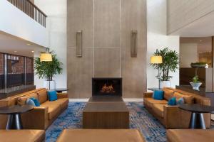 a lobby with couches and a fireplace at Hilton Boston Dedham in Dedham