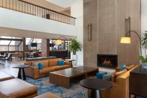 a lobby with couches and a fireplace at Hilton Boston Dedham in Dedham