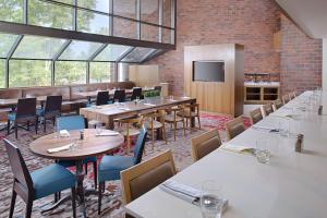 a restaurant with tables and chairs and a tv at Hilton Boston Dedham in Dedham