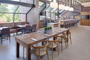 a restaurant with a large wooden table and chairs at Hilton Boston Dedham in Dedham