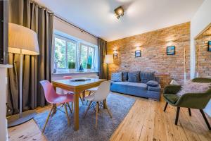 - un salon avec une table, des chaises et un canapé dans l'établissement Pomorskie Apartamenty Enter House, à Sopot