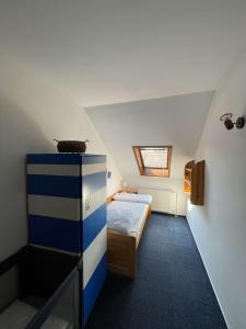 a small attic bedroom with a bed and a drawer at Apartmány Močovice 