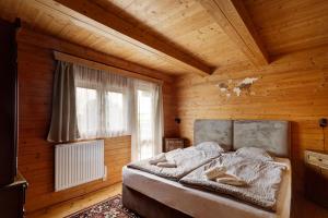 a bedroom with a bed in a wooden room at Private summer house with swimming pool, beach bar and pit for football and volleyball in Hvězdonice