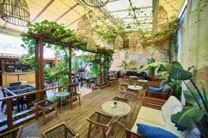 a restaurant with tables and chairs and plants at AlvorKiteCenter Guesthouse in Alvor