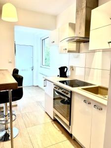 a kitchen with white cabinets and a table and a counter at Familly Apartament 4 in Międzyzdroje