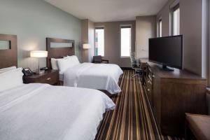 a hotel room with two beds and a flat screen tv at Hampton Inn & Suites Denver Downtown Convention Center in Denver