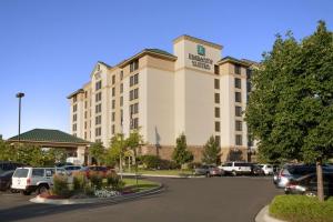 a hotel building with cars parked in a parking lot at Embassy Suites by Hilton Denver International Airport in Denver