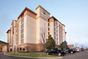 a hotel with cars parked in a parking lot at Embassy Suites by Hilton Denver International Airport in Denver
