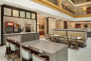 a restaurant with tables and chairs and a bar at Embassy Suites by Hilton Denver International Airport in Denver