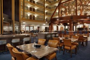 a restaurant with tables and chairs and a bar at Embassy Suites by Hilton Denver International Airport in Denver