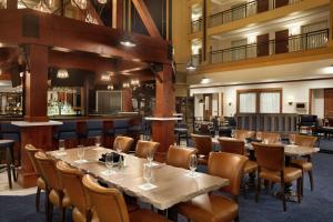 a restaurant with tables and chairs and a bar at Embassy Suites by Hilton Denver International Airport in Denver