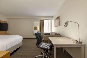 a hotel room with a bed and a desk and a bed at Embassy Suites by Hilton Denver International Airport in Denver