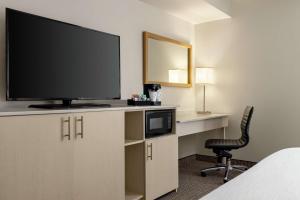 a hotel room with a flat screen tv and a chair at Embassy Suites by Hilton Denver International Airport in Denver