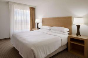 a hotel room with a large white bed and a window at Embassy Suites by Hilton Denver International Airport in Denver
