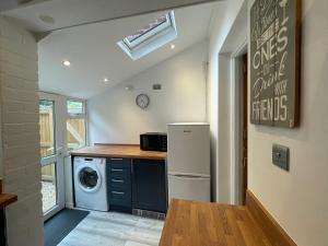 una cocina con lavadora y secadora en una casa en Tucked away house in Macclesfield en Macclesfield