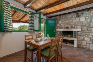 a dining room with a table and a stone fireplace at Trapula stone paradise in Maslinica