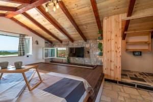 a living room with a stone fireplace and a table at Trapula stone paradise in Maslinica