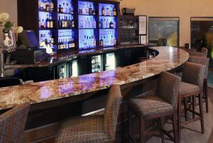 a bar with chairs and a counter in a room at DoubleTree by Hilton Hotel Denver - Thornton in Thornton