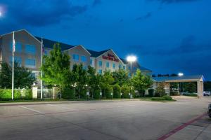 um parque de estacionamento em frente a um hotel à noite em Hilton Garden Inn Denton em Denton