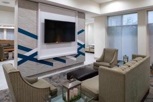 ein Wohnzimmer mit einem Flachbild-TV an der Wand in der Unterkunft Hilton Garden Inn Denton in Denton