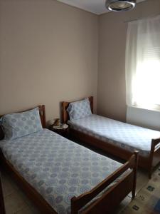 two beds sitting in a room with a window at Summer House Toula in Nea Kalikratia