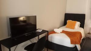 een kleine slaapkamer met een bed en een televisie bij Areal de Santa Bárbara Sea View in Ribeira Grande