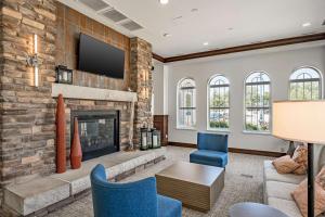 a living room with a fireplace and a tv at Hilton Garden Inn Granbury in Granbury