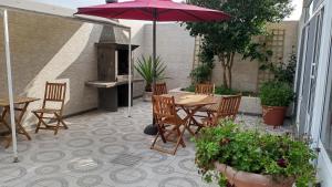 patio con tavolo, sedie e ombrellone di Areal de Santa Bárbara Sea View a Ribeira Grande