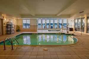 a swimming pool in a large room with windows at Hilton Garden Inn Granbury in Granbury