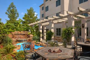 a patio with a fire pit and a building at Hilton Garden Inn DFW Airport South in Irving