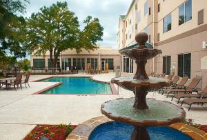 una fuente frente a un edificio con piscina en Hilton Garden Inn DFW Airport South, en Irving