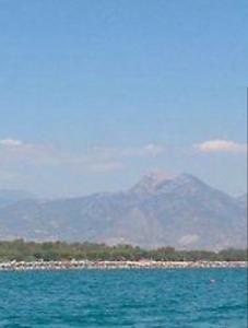 a mountain in the background of a body of water at B&B Villa Anna in Sibari