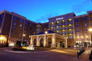 - un bâtiment d'hôtel avec une fontaine en face dans l'établissement Hilton Dallas Southlake Town Square, à Southlake