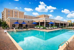 una piscina in un hotel con sedie e ombrelloni di Hilton Dallas Southlake Town Square a Southlake