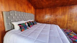 a bedroom with a white bed with wooden walls at Hanan Pacha Lodge in Puno