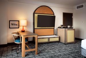 a hotel room with a desk and a flat screen tv at Hilton Dallas Southlake Town Square in Southlake