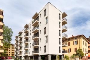 ein Apartmenthaus mit weißer Fassade in der Unterkunft Central Superior Suites - Free Parking in Lugano