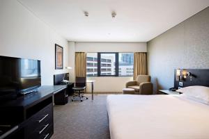 a hotel room with a bed and a flat screen tv at Hilton Darwin in Darwin