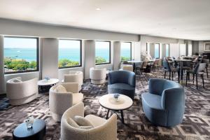 a waiting room with chairs and tables and windows at Hilton Darwin in Darwin