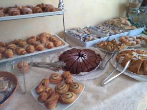 una tavola ricoperta con diversi tipi di prodotti da forno e torte di Hotel Gloria a Gabicce Mare