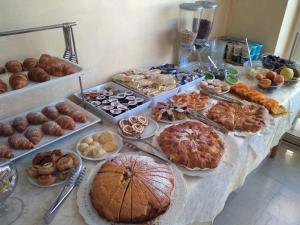 una mesa llena de diferentes tipos de pasteles y tartas en Hotel Gloria, en Gabicce Mare