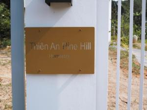 um sinal que lê então um pinhal sobre uma cerca em Thien An Pine Hill Homestay Hue em Hue