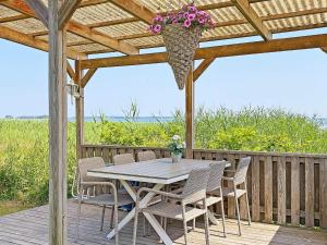 eine Holzterrasse mit einem Tisch mit Stühlen und einem Blumenkorb in der Unterkunft 6 person holiday home in ODENSBACKEN-By Traum in Odensbacken